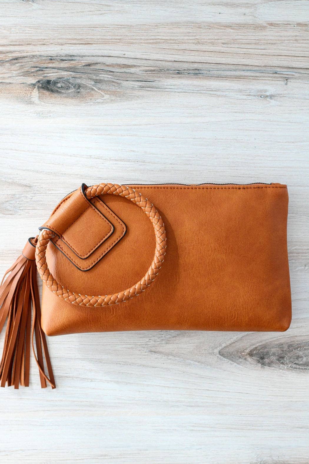Stylish Leather Wristlet/Clutch with braided handle and tassel, perfect for adding flair to any outfit.