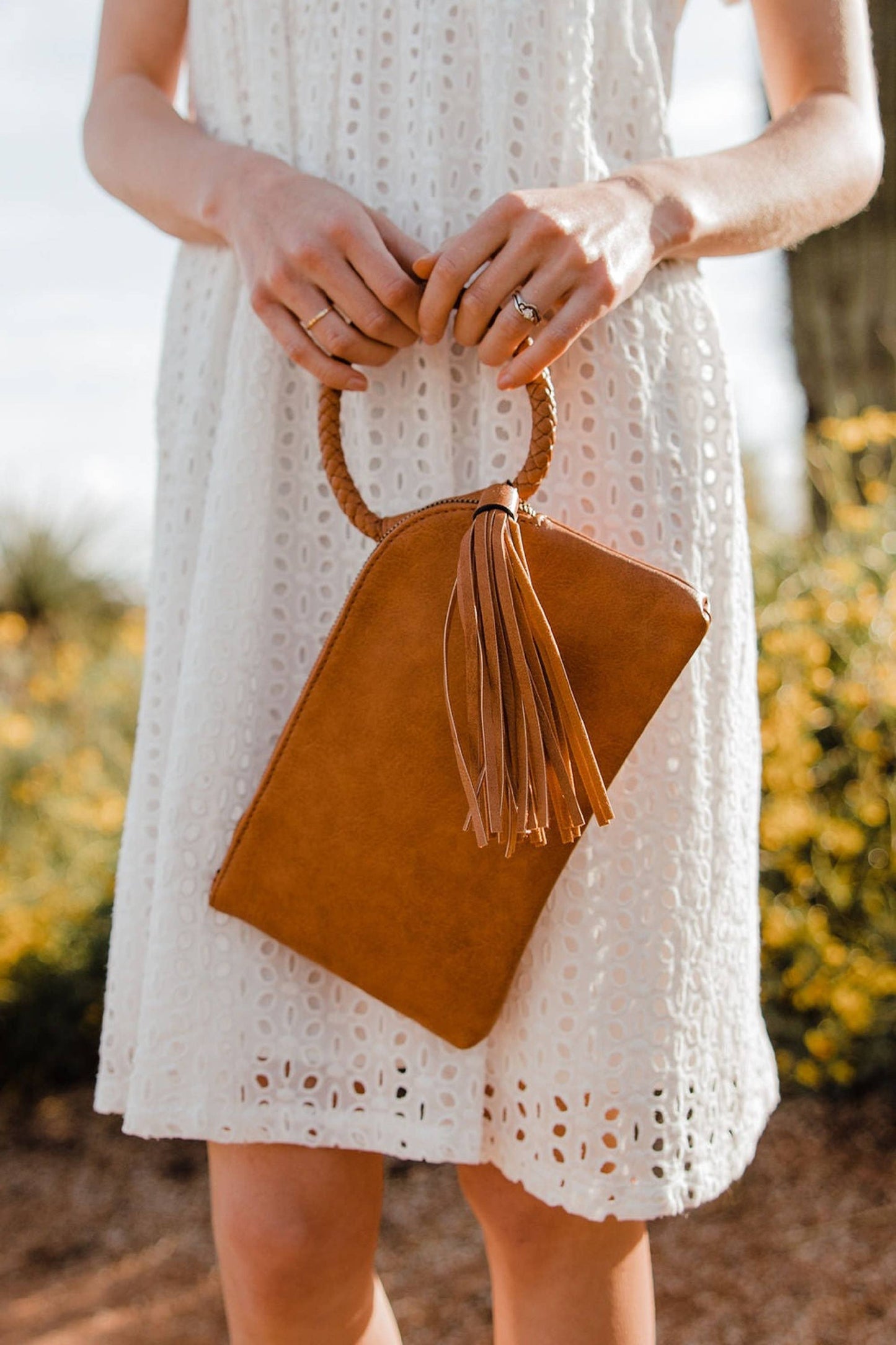 Stylish Leather Wristlet/Clutch with a braided handle and tassel, perfect for adding flair to any outfit.