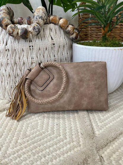 Stylish Leather Wristlet/Clutch featuring a braided strap and tassel, perfect for adding flair to any outfit.